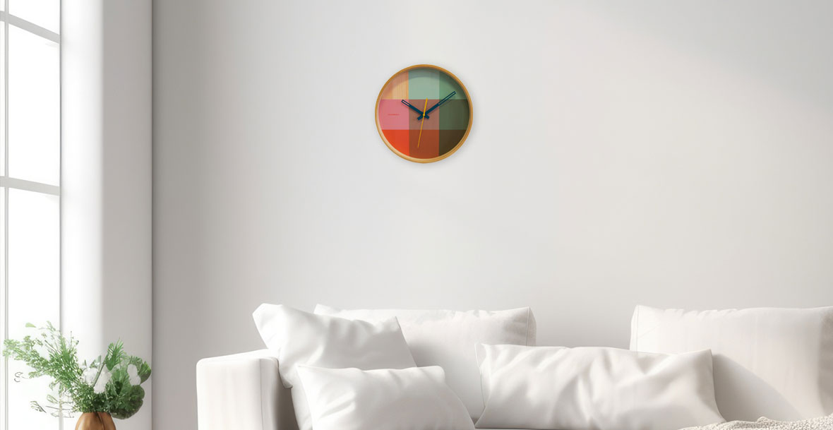 Eine farbenfrohe Designer Wanduhr an einer weißen Wand Eine farbenfrohe Designer Wanduhr an einer weißen Wand